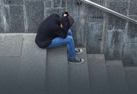 Person sitting on steps head in hands