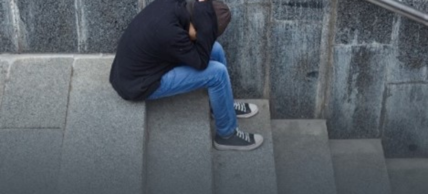 Person sitting on steps head in hands